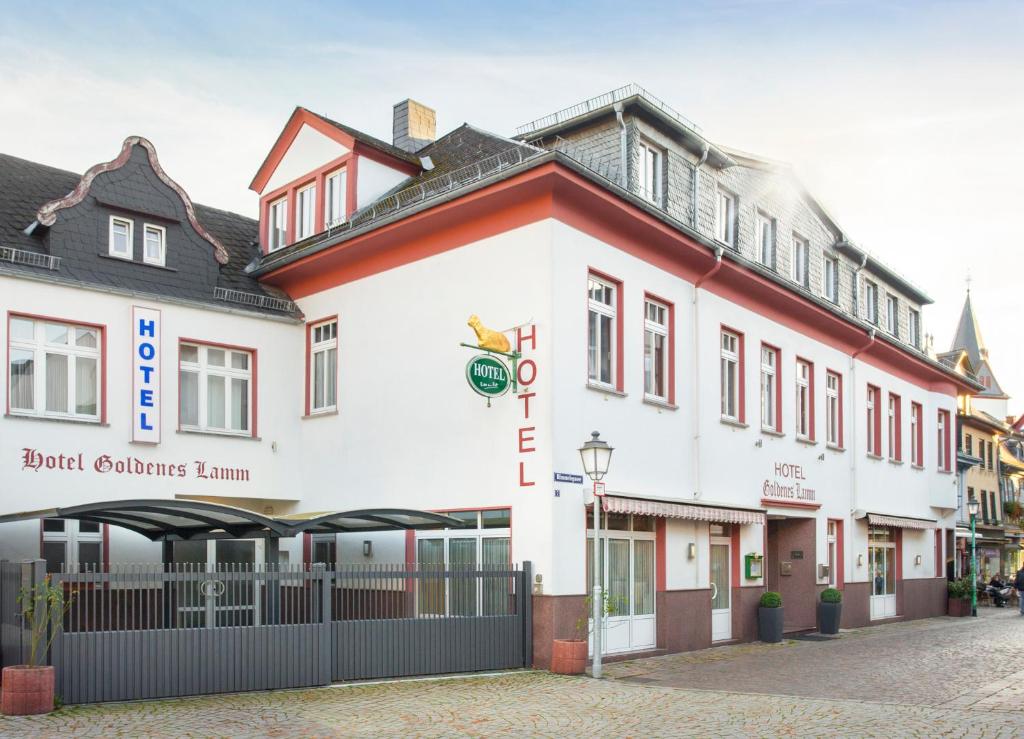 ein großes weißes Gebäude mit roter Ausstattung in der Unterkunft Hotel Goldenes Lamm in Idstein