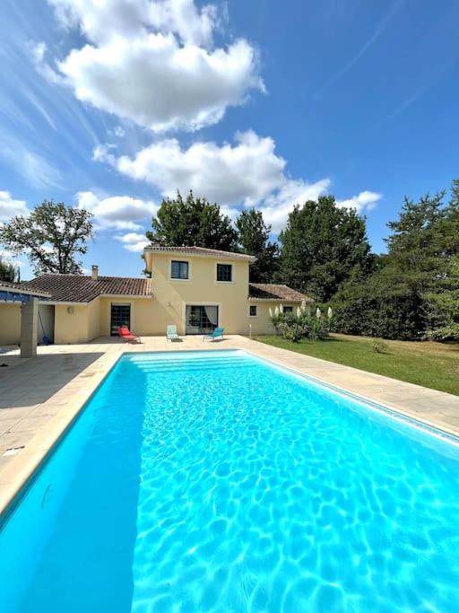 une grande piscine bleue devant une maison dans l'établissement Maison de vacances avec piscine, à Chancelade
