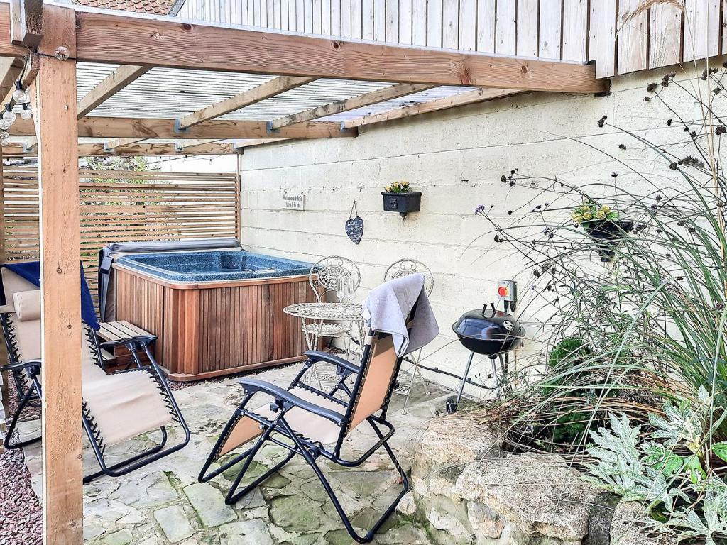 Goxhill的住宿－Hayloft- Uk31532，一个带桌椅和热水浴池的庭院