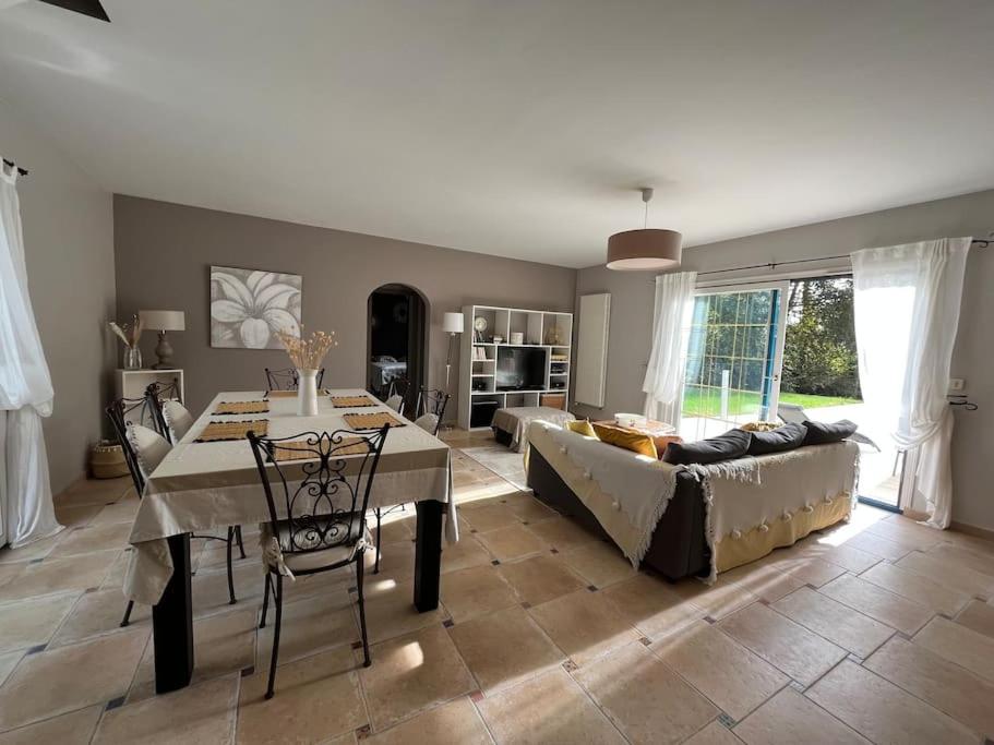 ein Wohnzimmer mit einem Tisch und einem Sofa in der Unterkunft Maison de vacances avec piscine in Chancelade