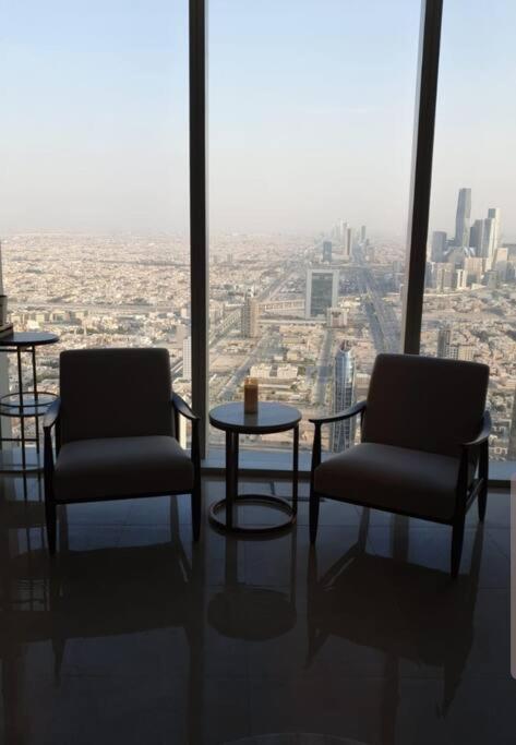 two chairs and a table in a room with a view at شقة خاصة برج رافال in Riyadh