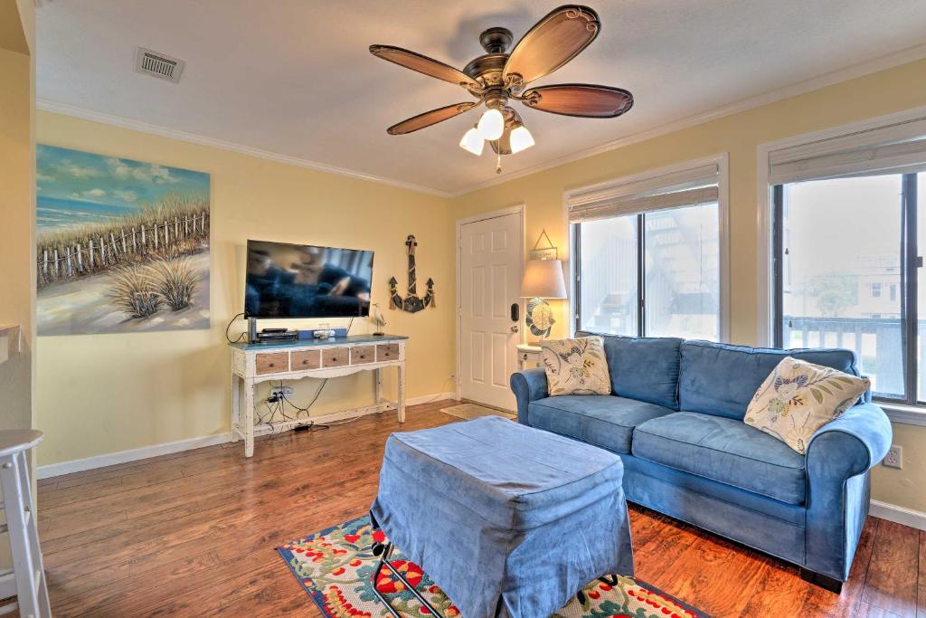 a living room with a blue couch and a ceiling fan at Convenient PCB Condo with Pool Access Walk to Beach in Panama City Beach