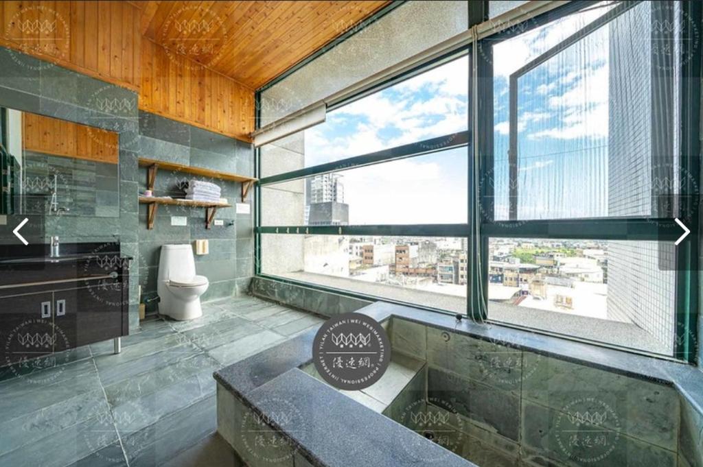 a bathroom with a large window and a bath tub at 元本山湯宿 in Jiaoxi