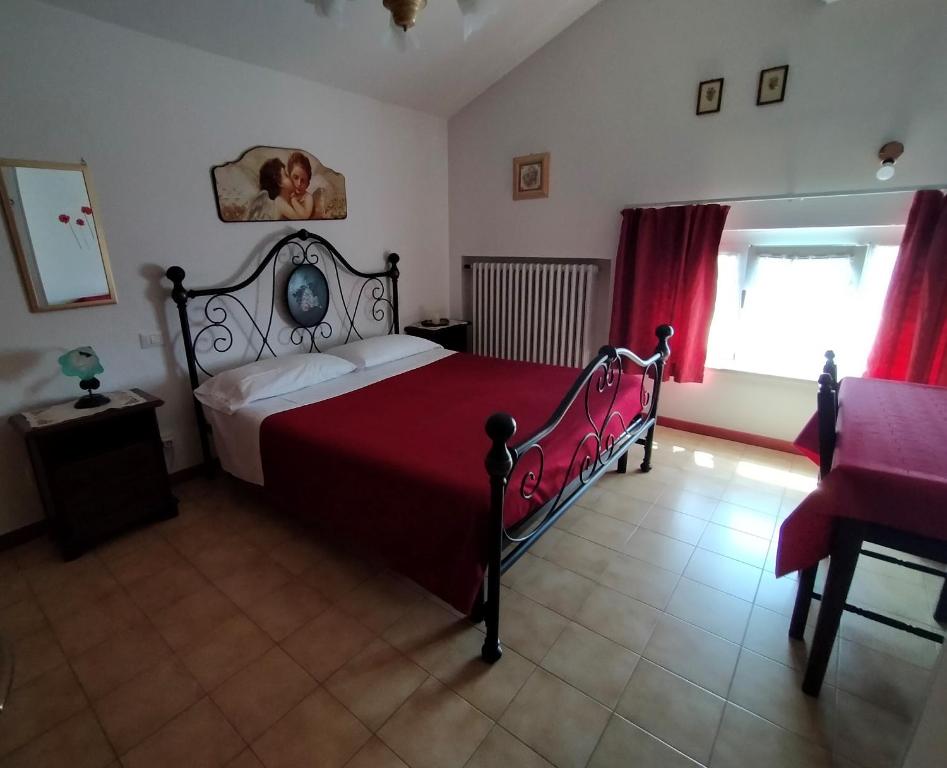 a bedroom with a bed and a window with red curtains at La Magnolia - Fano in Fano