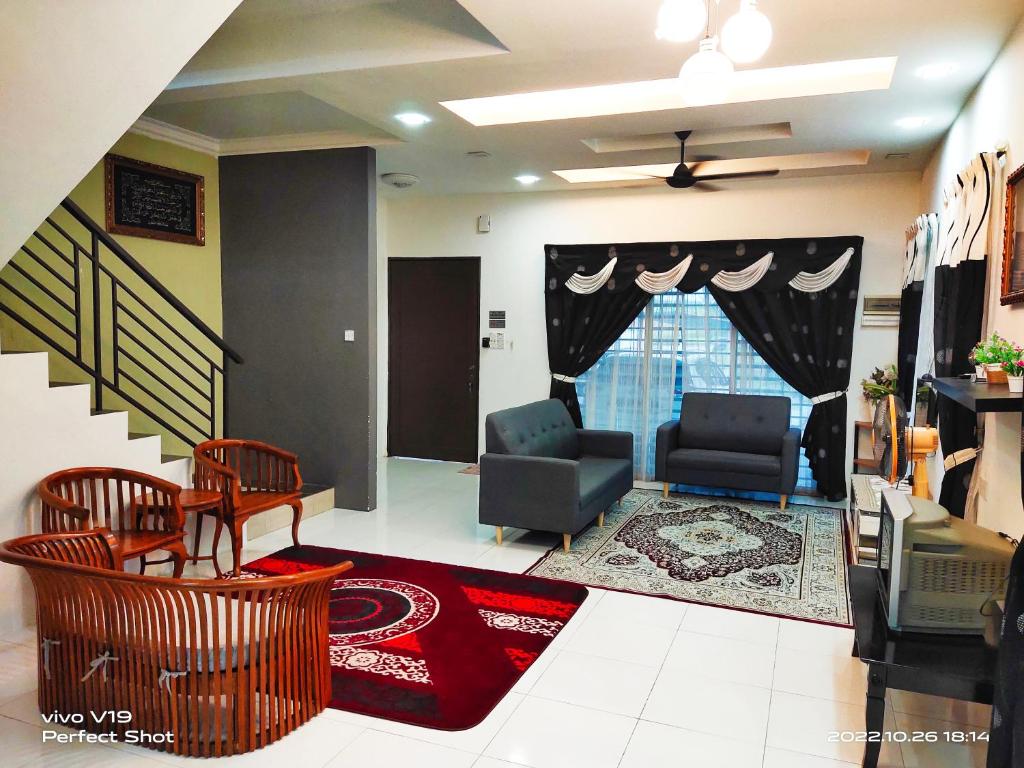 a living room with two chairs and a couch at Sweet40 Homestay in Kampong Batu Lapan