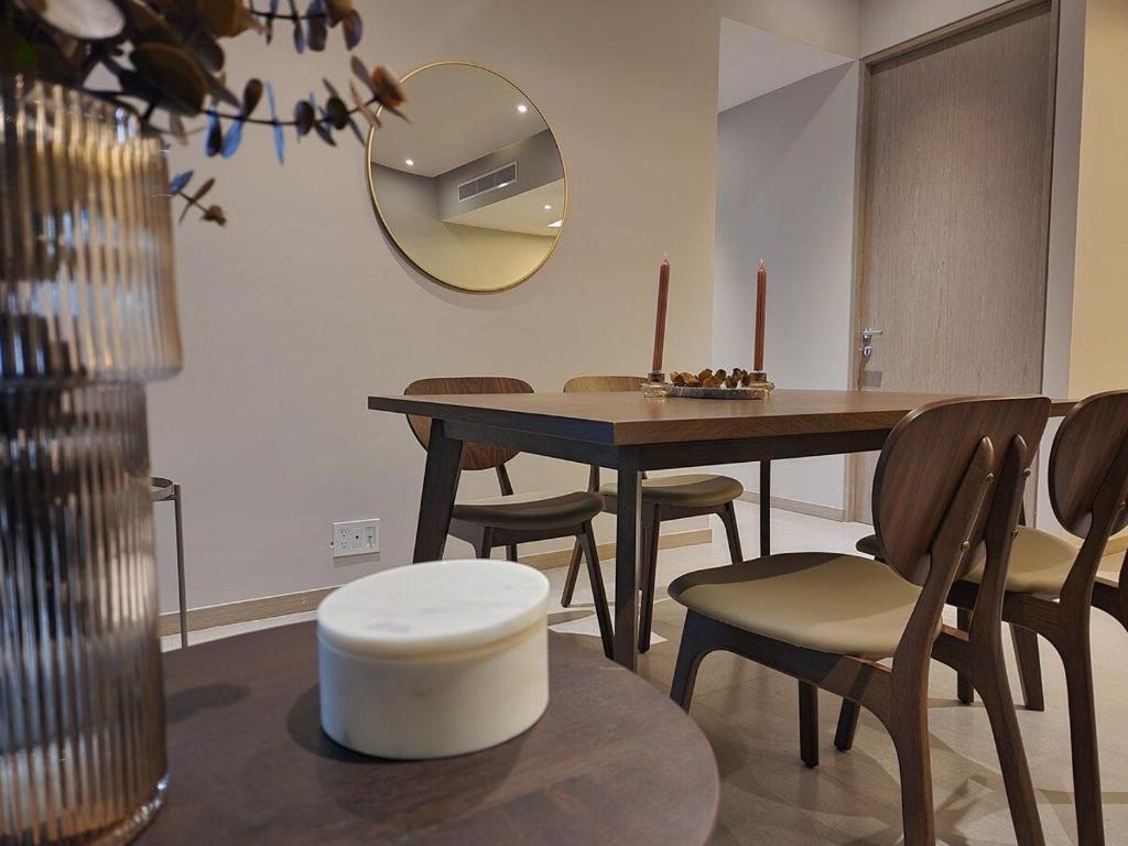 een eetkamer met een tafel en stoelen en een spiegel bij Luxury Condo Paradox Santa Fe By Bamboo Skylife in Mexico-Stad