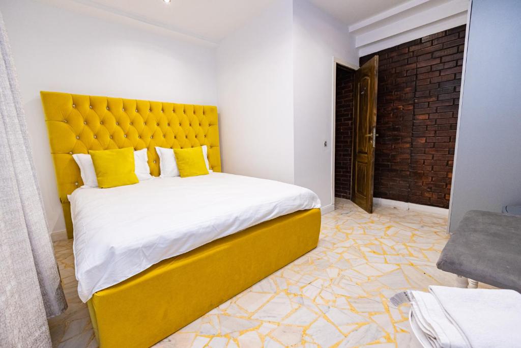 1 dormitorio con 1 cama grande y cabecero amarillo en Pensiunea Ewo en Iaşi