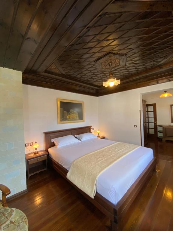 um quarto com uma cama grande e um tecto em madeira em Boutique Hotel Muzaka (Historic Center) em Berat