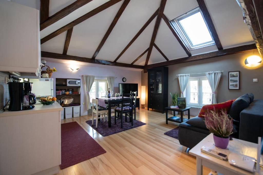 una cucina e un soggiorno con soffitto con travi a vista di Apartment Vanja a Opatija