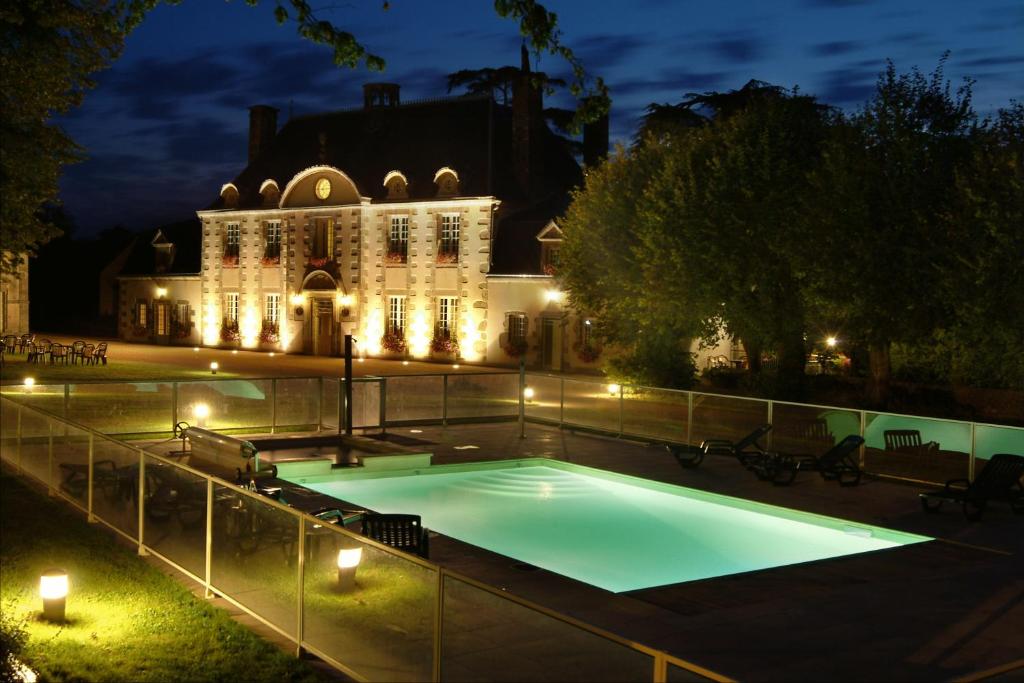 a swimming pool in front of a building at night at Logis La Marjolaine in Moulay