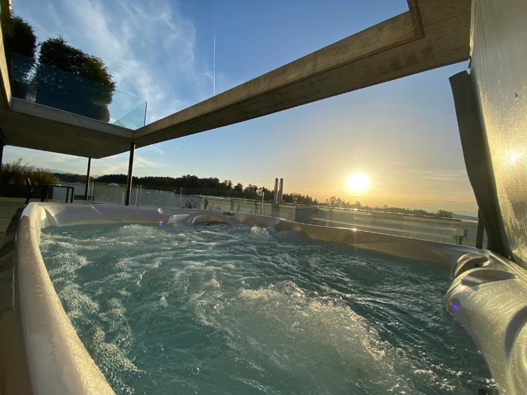 bañera de hidromasaje con puesta de sol al fondo en Luxusloft mit warmem Outdoor Whirlpool, 