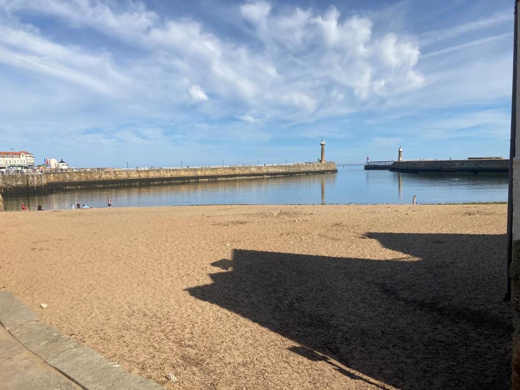 una playa con muelle y un cuerpo de agua en Duke of York en Whitby