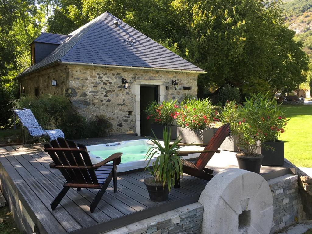 two chairs sitting on a wooden deck next to a pool at Lodge ou Gîte de caractére avec jaccuzi spa piscine in Argelès-Gazost