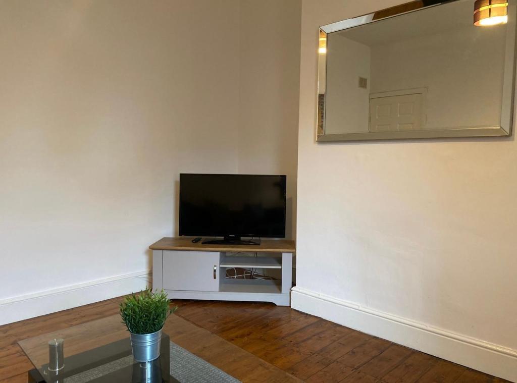 a living room with a tv and a mirror at Alexander Apartments Gateshead North in Gateshead
