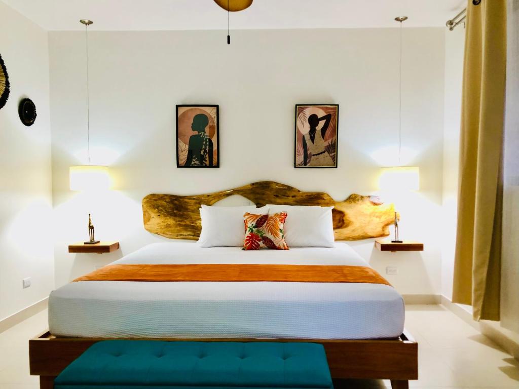 um quarto com uma cama grande e uma cabeceira em madeira em Olinca Boutique Hotel em Puerto Viejo