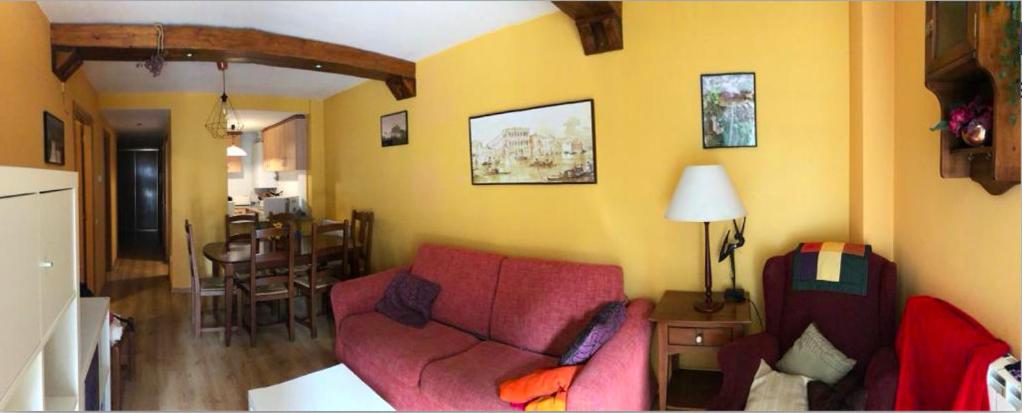 uma sala de estar com um sofá vermelho e uma sala de jantar em CHECK IN CASAS Casa Elson em Cerler