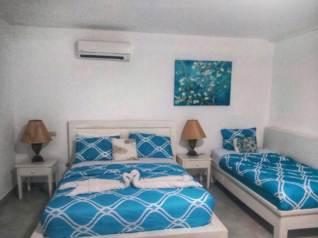 een slaapkamer met 2 bedden en 2 lampen bij Caribbean and sun Punta Cana in Punta Cana