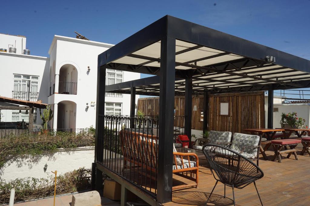 een zwarte pergola met stoelen en tafels op een patio bij Hostal Solar in Arequipa