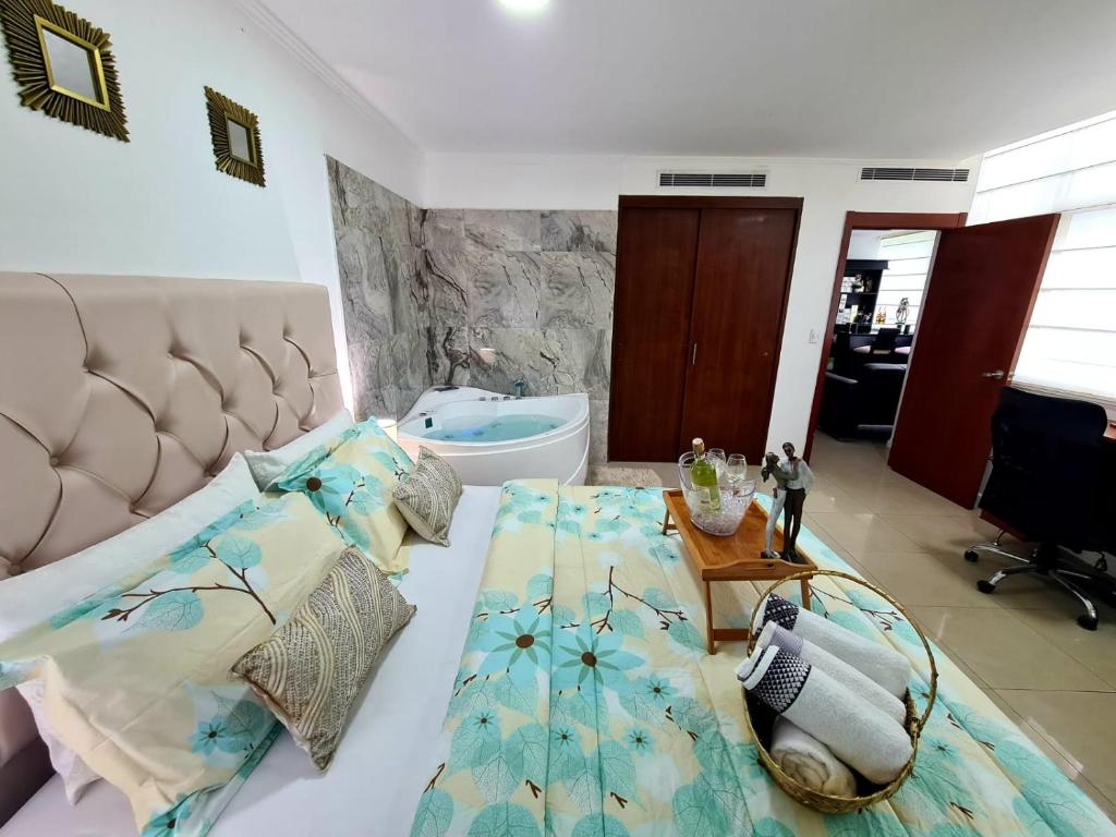 a bedroom with a bed and a bathroom with a tub at Ecusuites Jacuzzi Executive Dpto Riverfront l puerto santa ana in Guayaquil
