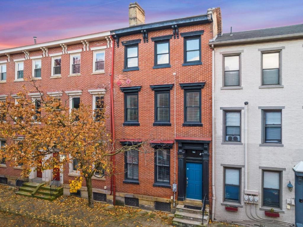 a red brick building with blue doors on a street at Stylish 4 Bedroom Loft Home, North Shore, City Skyline View Close to NHL, NFL in Pittsburgh