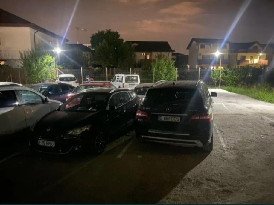 un groupe de voitures garées sur un parking la nuit dans l'établissement ModernStudio, à Bragadiru