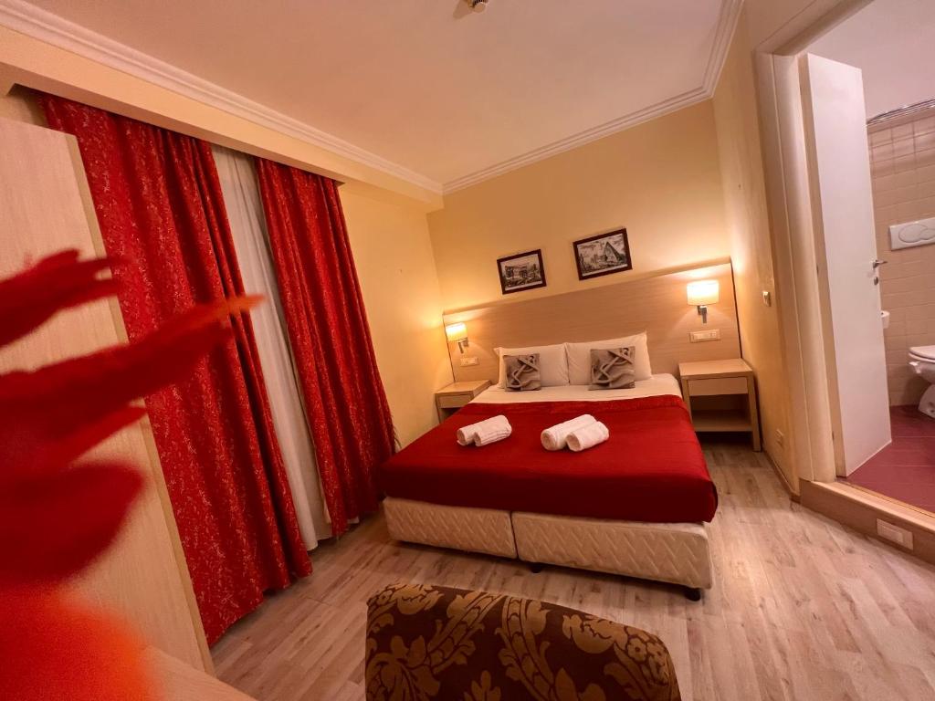 um quarto de hotel com uma cama com cortinas vermelhas em Booking House Rome em Roma