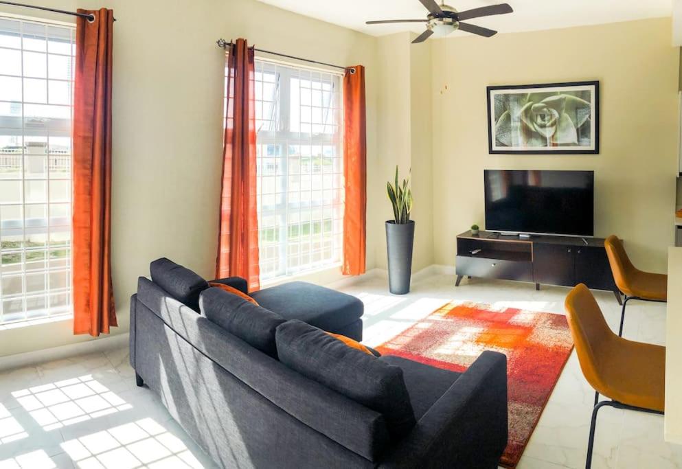 sala de estar con sofá y TV de pantalla plana en Suite Retreat at The Lofts, en Kingston