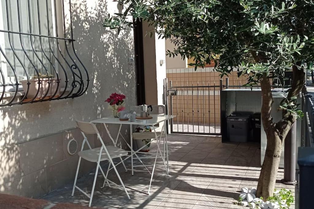 a table and chairs in a courtyard with a tree at Soggiorno a 5 stelle, tra mare, cultura e natura in Cattolica