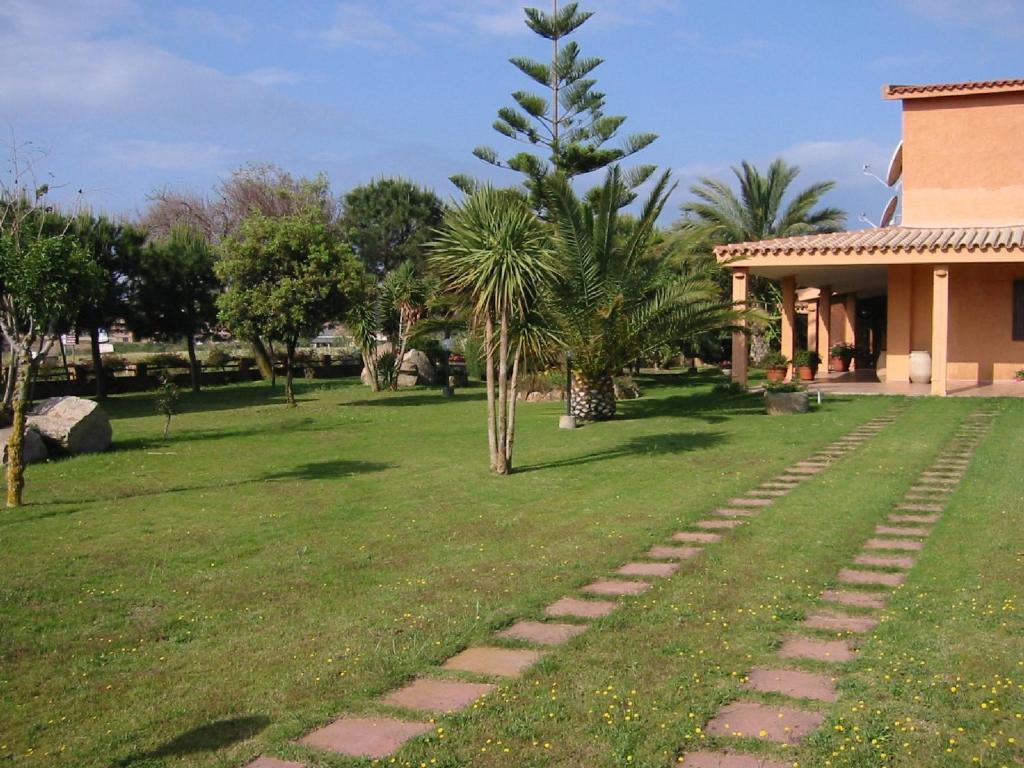 a garden with a path in front of a house at Hotel Su Giudeu in Chia
