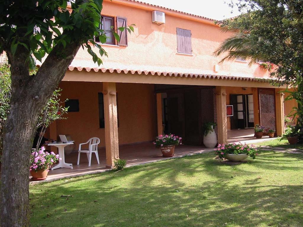 an outside view of a house with a yard at Hotel Su Giudeu in Chia