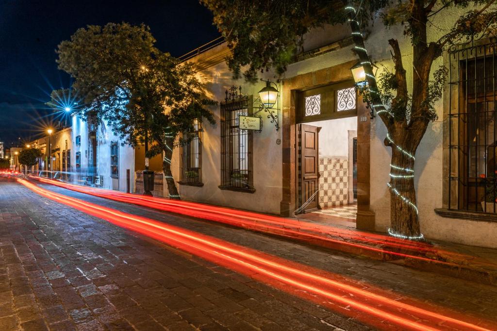 una strada di città di notte con strisce di luce di Hotel Meson de Isabel a Querétaro