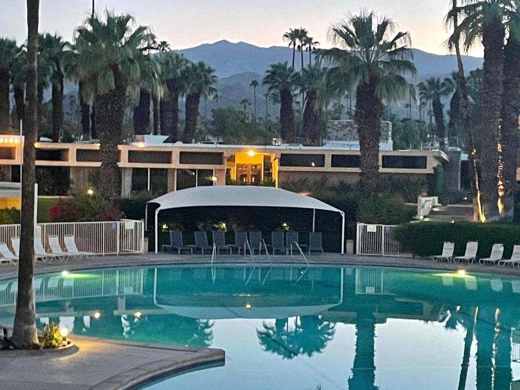 a resort with a swimming pool in front of a building at Large Creekside Studio at Shadow Mountain Resort and Club in Palm Desert