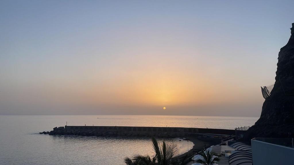 una puesta de sol sobre el agua con un muelle en Primero el Wiro, en Puerto