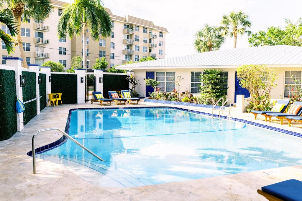 uma piscina num hotel com cadeiras e um edifício em Casa Cordova By Lowkl em Fort Lauderdale