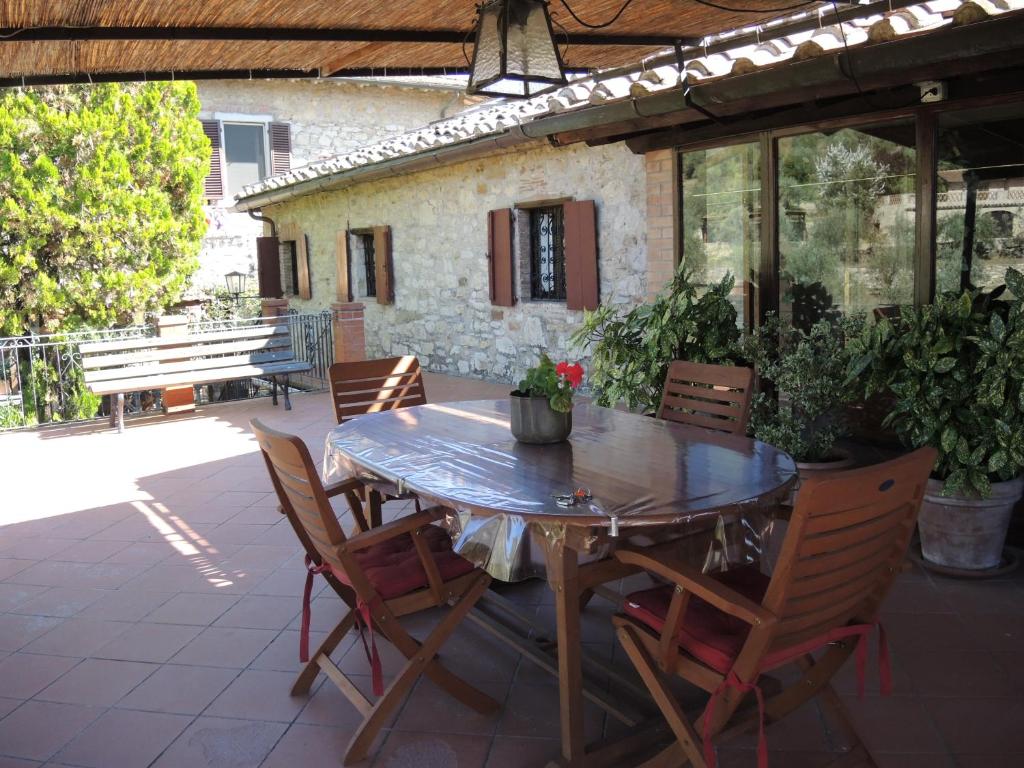 a wooden table and chairs on a patio at "La Casa di Maria Luce" con terrazza panoramica in Gaiole in Chianti
