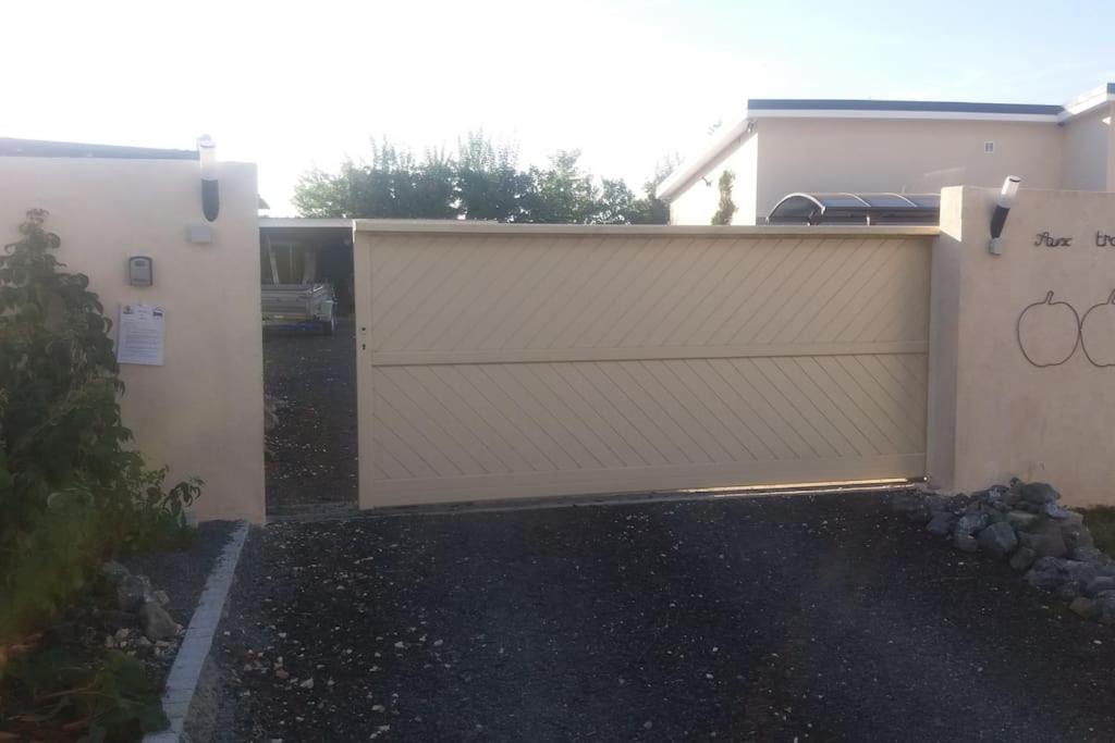 a white garage door on the side of a house at meublé entier indépendant en contigu de ma maison in Saint-Georges-sur-Moulon