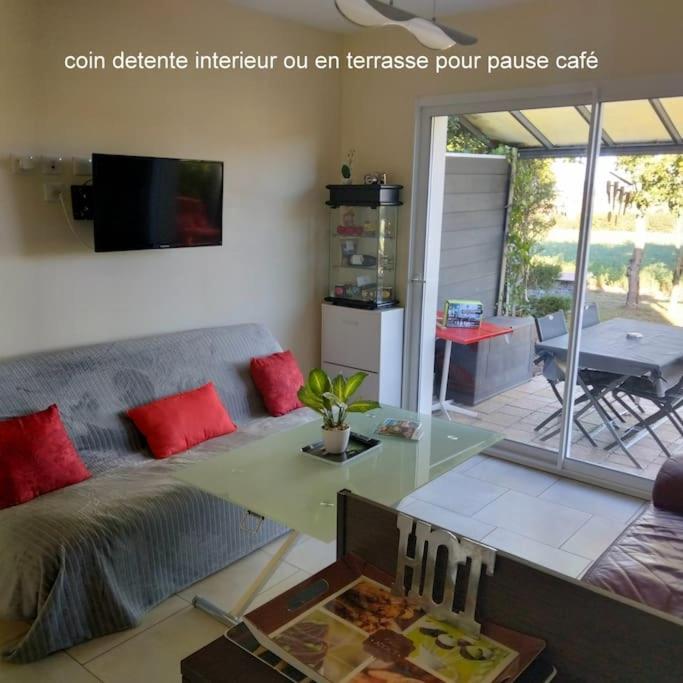 a living room with a couch and a table at meublé entier indépendant en contigu de ma maison in Saint-Georges-sur-Moulon