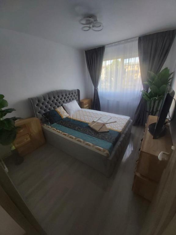 a bedroom with a bed and a window at Breaza Comfort Apartment in Breaza