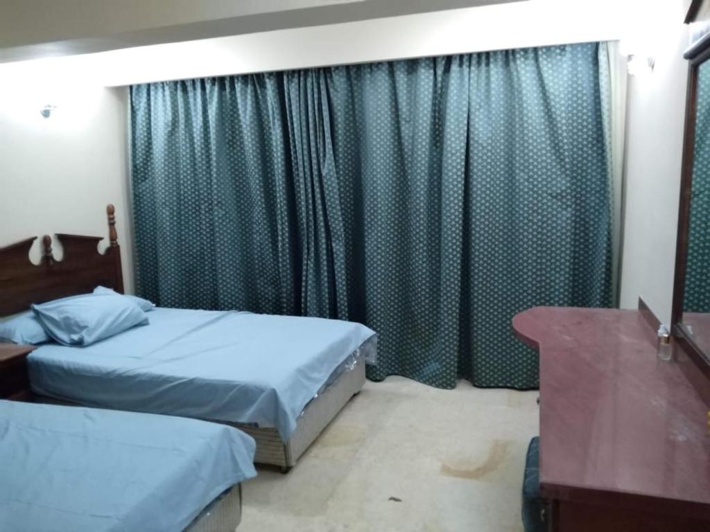 - une chambre avec 2 lits et une fenêtre avec des rideaux dans l'établissement Apartment, à Hurghada