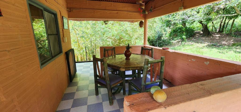 una mesa y sillas en el porche de una casa en Hostel Finca La Gordita, en Calabazo