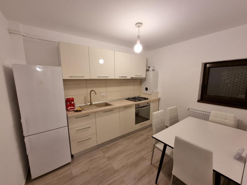 una cucina con frigorifero bianco e tavolo di DREAMS ESCAPE a Craiova