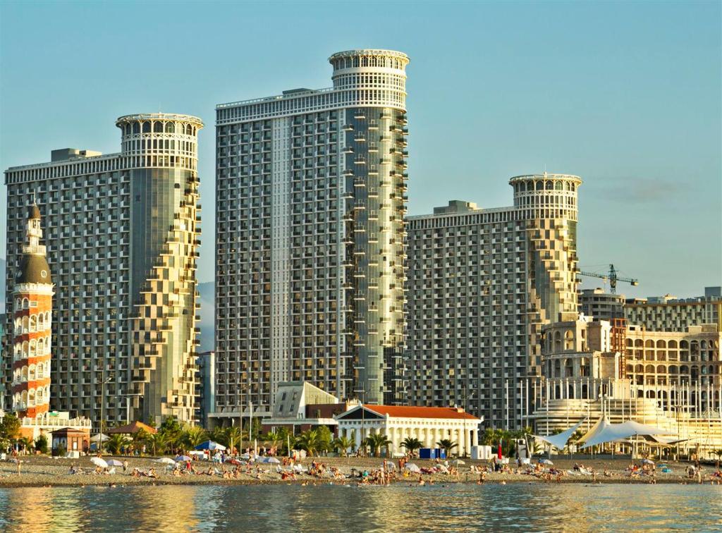 Blick auf eine Stadt mit hohen Gebäuden und einem Strand in der Unterkunft ORBI BATUMi SEA VIEW in Batumi