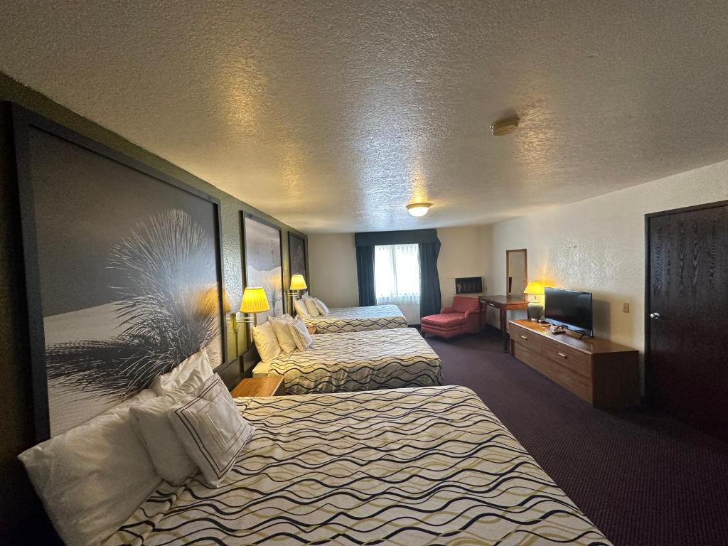 a hotel room with two beds and a television at Simple Rewards Inn in Ruidoso