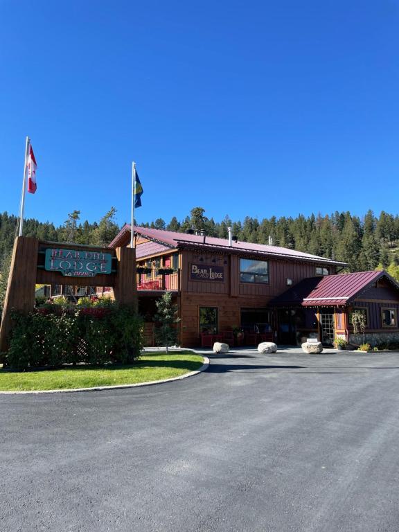 a building with two flags in front of a road at Bear Hill Lodge in Jasper