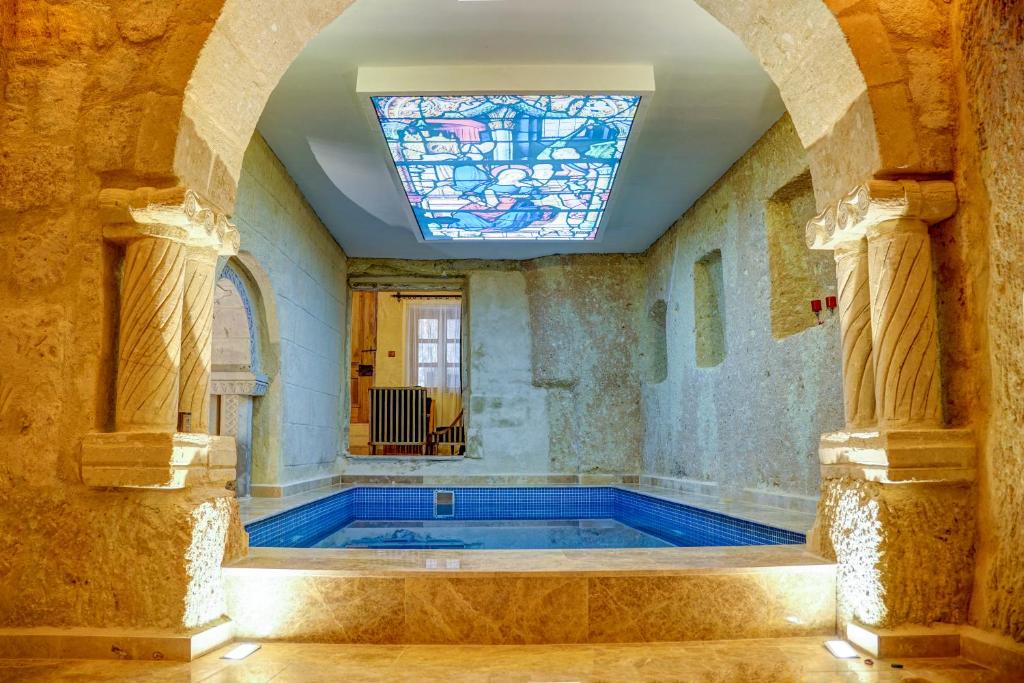 a swimming pool in a room with a stained glass window at Calypso Cave Suites in Ürgüp