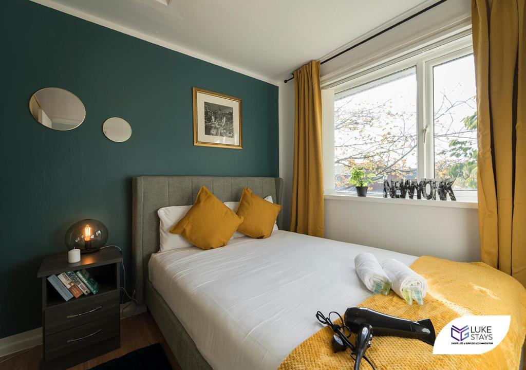 a bedroom with a bed with yellow pillows and a window at Luke Stays - Ashdown in Durham