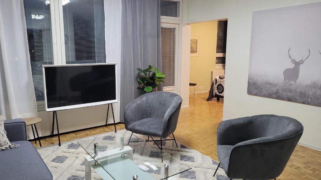 a living room with two chairs and a television at Apartment Puijo & autotalli in Kuopio