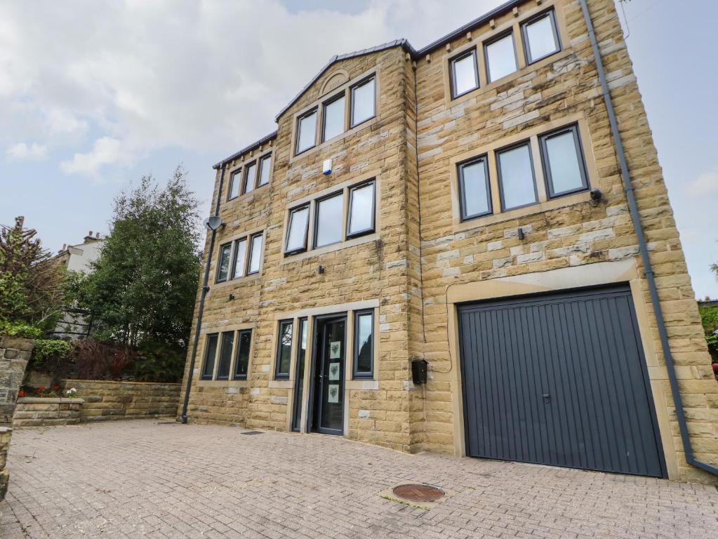 a large brick building with a garage at Vista Tasso in Holmfirth