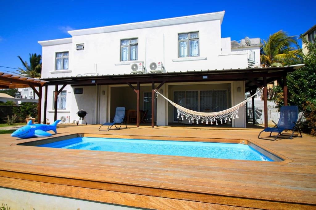 a house with a swimming pool on a wooden deck at Villa Quatre coco avec piscine, accès plage à pied in Mont Choisy