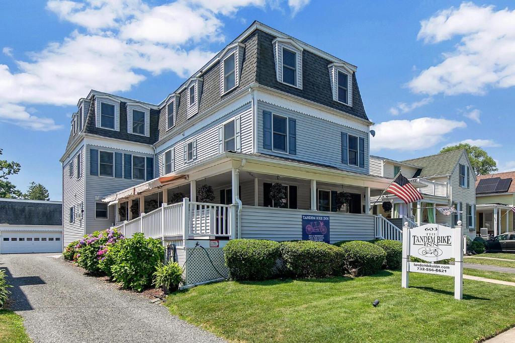 une grande maison avec un panneau en face de celle-ci dans l'établissement Tandem Bike Inn, à Belmar